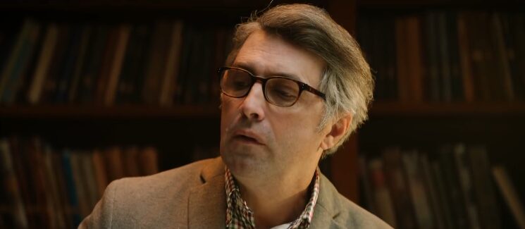 Business professional wearing glasses in office library setting in Kissflow workflow automation commercial