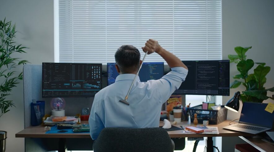 Office worker sitting at his desk and scratching his back for Vonage commercial