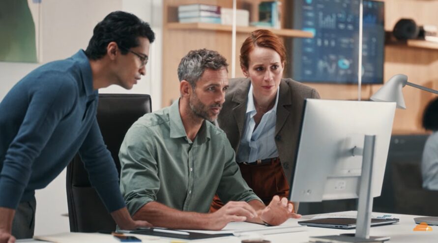 three professionals staring at a computer for cloudfare commercial