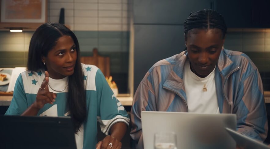 two professionals sitting behind laptops for Deloitte commercial