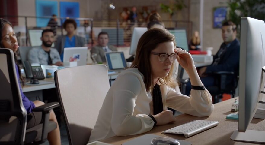 Professionals in an office looking at a desktop screen for Salesforce commercial