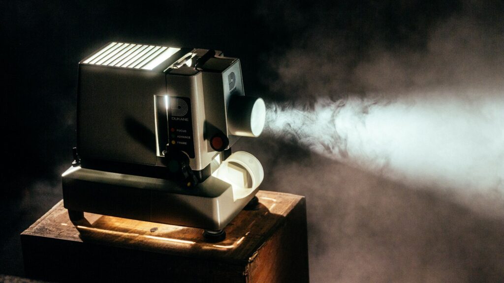 A film projector beam cutting through smoke in a dark room
