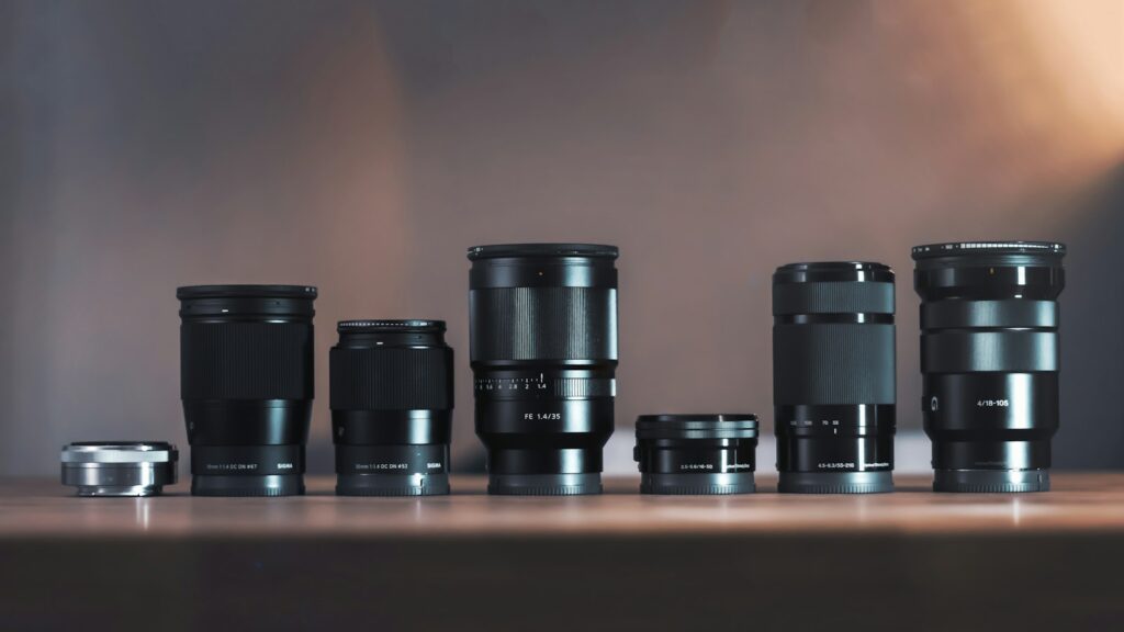 Six camera lenses lined up side by side on a table